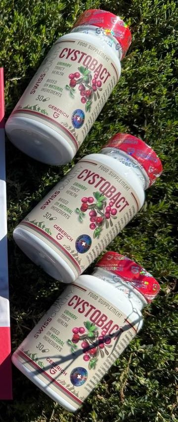 Trois flacons de Cystobact posés sur l’herbe au soleil
